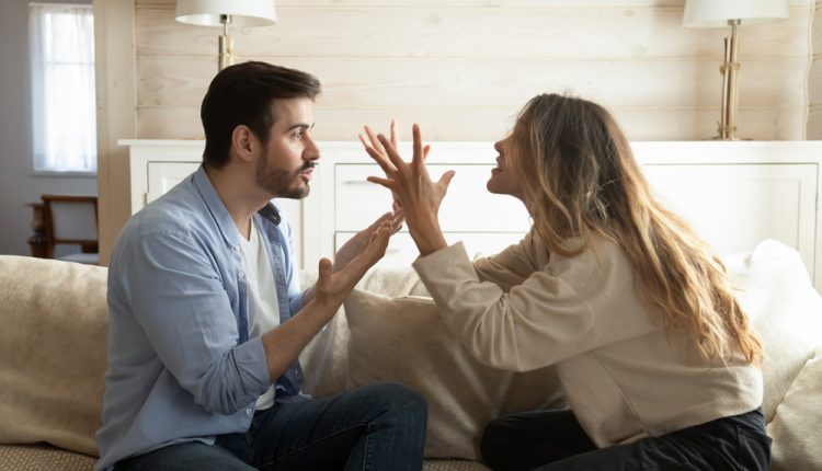 Emotional,Annoyed,Stressed,Couple,Sitting,On,Couch,,Arguing,At,Home.