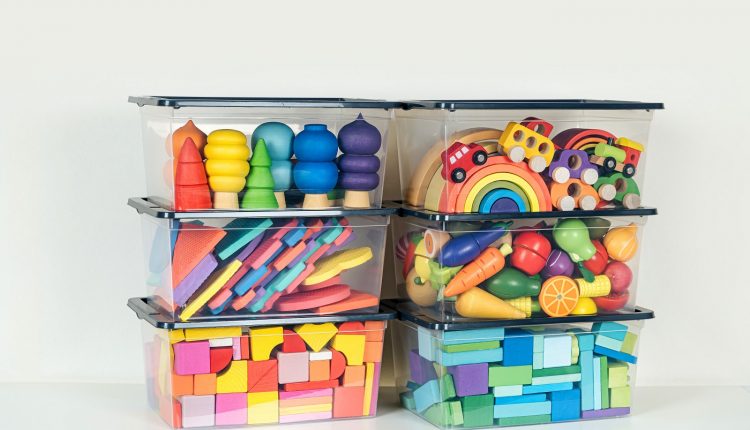 Transparent plastic containers with various children’s toys on shelves. Organizing and Storage Ideas in nursery. Space organizing at childrens room. Toys sorting system.