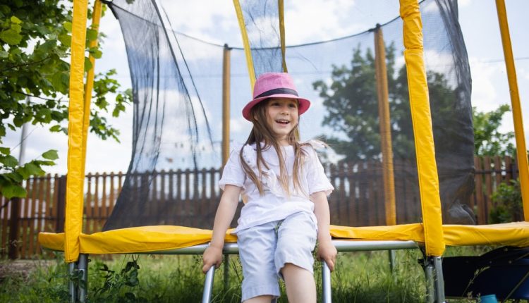 Backyard,Playground.,Happy,Child,Sitting,On,Trampoline,In,Summer,Outdoor.